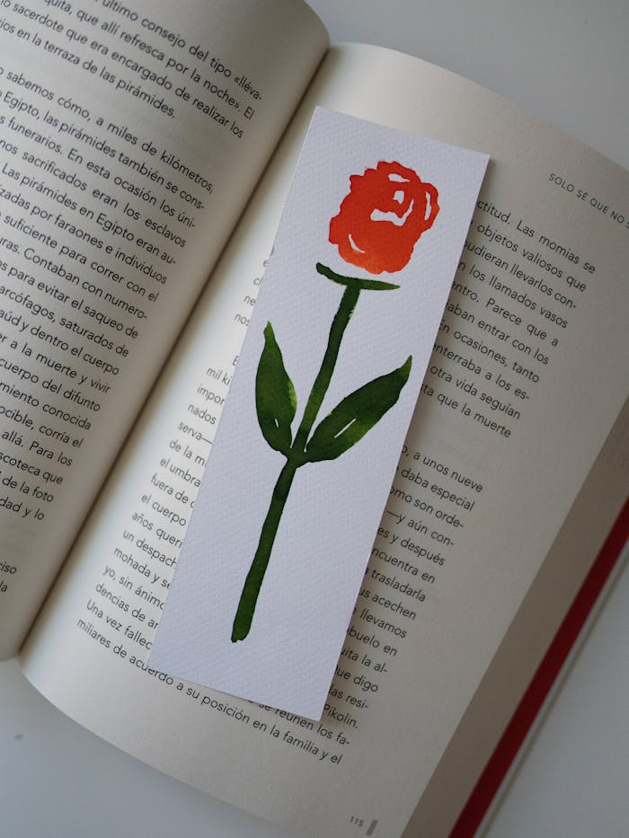 A handmade rose bookmark placed on an open book page, offering a classic and artistic touch.